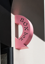 Pink curved arrow sign with lettering shown as a customisation example