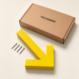 Yellow arrow sign beside fixing screws and The Signery presentation box